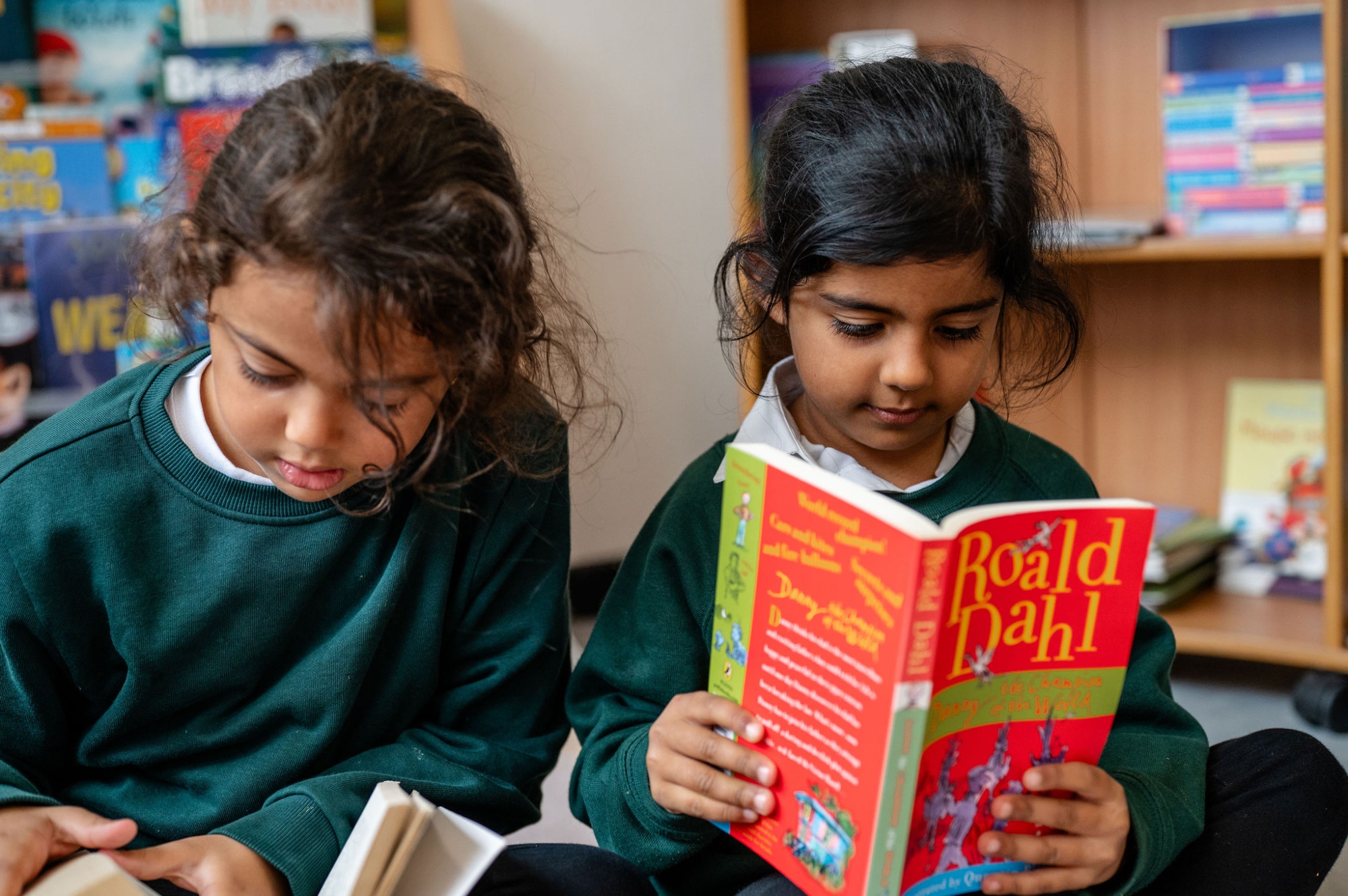2 pupils read books in the school library