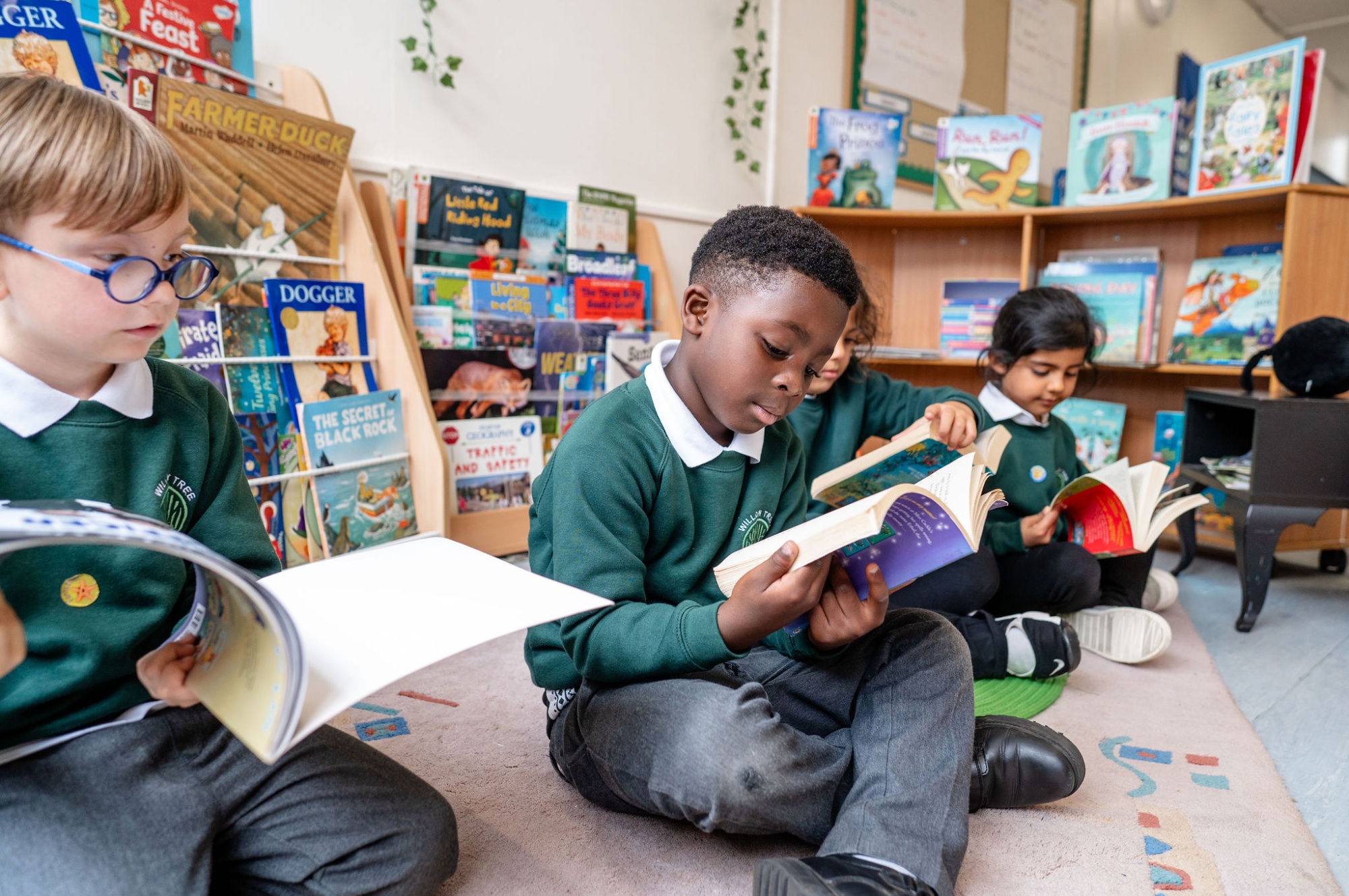 Pupils sit on the floor in the school library reading books